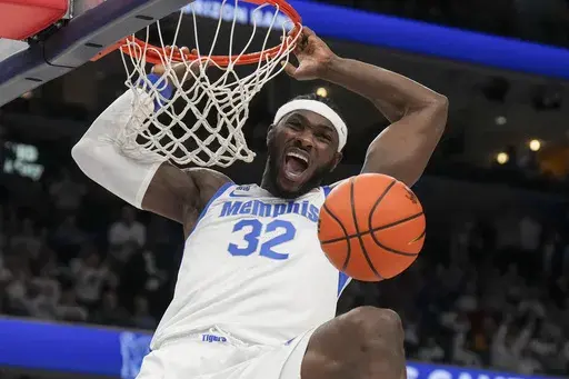 Memphis center Moussa Cisse (32) dunks the ball during the first half of an NCAA college basketball game against Mississippi, Saturday, Dec. 28, 2024, in Memphis, Tenn. (AP Photo/George Walker IV)