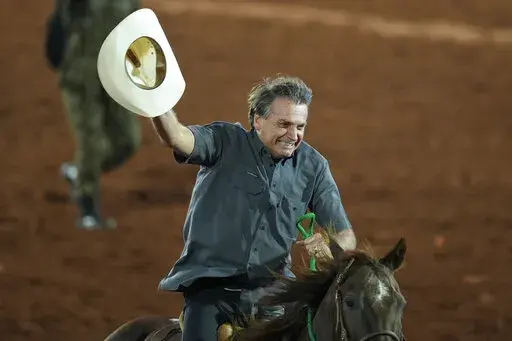 Brazilian President Jair Bolsonaro, who is running for a second term, rides a horse at the the Barretos Rodeo International Festival in Barretos, Sao Paulo state Brazil, Friday, Aug. 26, 2022. Brazil's general elections are scheduled for Oct. 2, 2022. (AP Photo/Andre Penner)