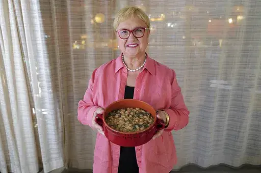 This image released by PBS shows celebrity chef Lidia Bastianich holding her recipe for escarole and white bean soup in Washington, DC on Nov. 7, 2022. The Emmy-award winning TV host, author and restaurateur explores the immigrant experience through food in the PBS special "Lidia Celebrates America: Flavors That Define Us.” (Meredith Nierman/PBS via AP)