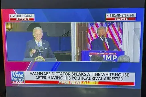 This image from video provided by Will Harris, shows a Fox News onscreen headline beneath a split-screen image of former President Donald Trump speaking to supporters live and President Joe Biden speaking earlier at the White House. The Fox News Channel chyron read, "Wannabe dictator speaks at the White House after having his political rival arrested." Fox said in a statement that "the chyron was taken down immediately and was addressed." (Will Harris via AP)