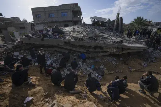 Palestinians search for bodies and survivors in the rubble of a residential building destroyed in an Israeli airstrike in Rafah, Gaza Strip, on March 4, 2024. An AP analysis of Gaza Health Ministry data finds the proportion of Palestinian women and children being killed in the Israel-Hamas war appears to have declined sharply. Israel faces heavy international criticism over unprecedented levels of civilian casualties in Gaza. (AP Photo/Fatima Shbair, File)