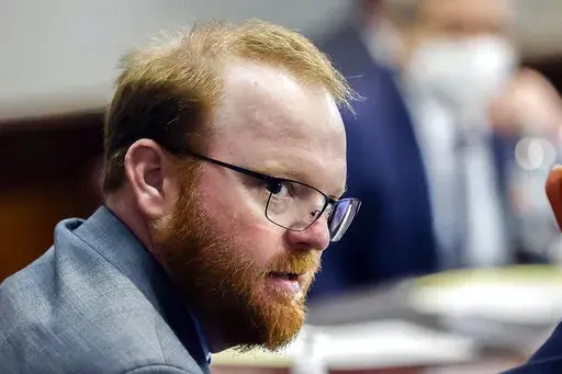 Travis McMichael looks on during the sentencing in his trial along with his father Greg McMichael and neighbor, William "Roddie" Bryan in the Glynn County Courthouse, on Jan. 7, 2022, in Brunswick, Ga. Travis McMichael, the man convicted of murder for shooting Ahmaud Arbery is withdrawing his guilty plea on a federal hate crime charge.  McMichael announced his decision Friday, Feb. 4, 2022.  (AP Photo/Stephen B. Morton, Pool, File)