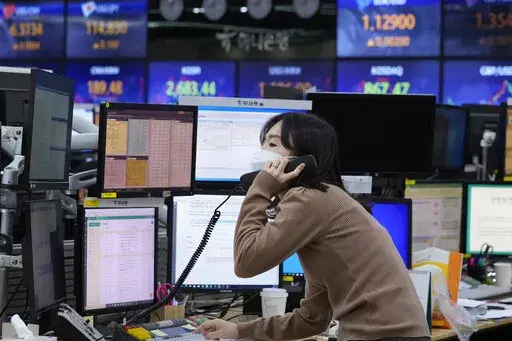 A currency trader talks on the phone at the foreign exchange dealing room of the KEB Hana Bank headquarters in Seoul, South Korea, Thursday, Feb. 24, 2022. Just what a vulnerable world economy didn’t need — a conflict that accelerates inflation, rattles markets and portends trouble for everyone from European consumers to indebted Chinese developers and families in Africa that are enduring soaring food prices. Russia’s attack on Ukraine and retaliatory sanctions from the West may not porten
