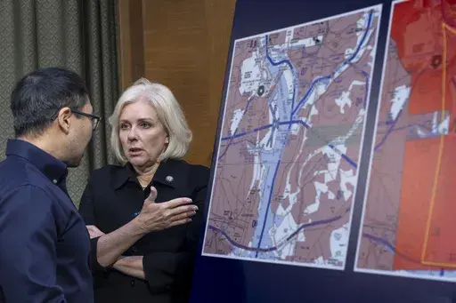 Jennifer Homendy, chair of the National Transportation Safety Board, center, stands next to map showing flight restrictions as the Senate Transportation Subcommittee holds a hearing to examine the preliminary report by the National Transportation Safety Board on the Jan. 29, 2024, midair collision of an Army Black Hawk helicopter and an American Airlines regional jet, on Capitol Hill in Washington, Thursday, March 27, 2025. (AP Photo/J. Scott Applewhite)