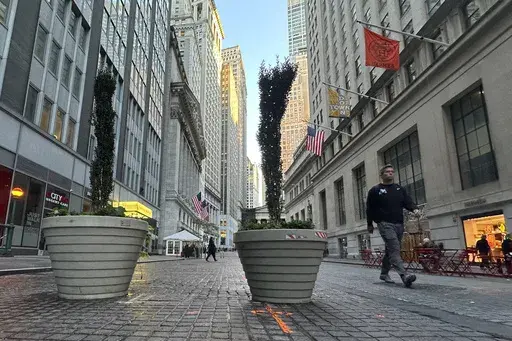 People pass the New York Stock Exchange, at rear, in New York's Financial District on Oct. 16, 2024. (AP Photo/Peter Morgan, File)