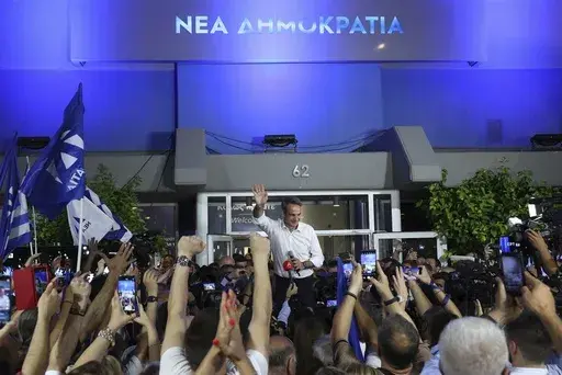 Kyriakos Mitsotakis leader of the center-right New Democracy waves to supporters outside the headquarters of the party in Athens, Greece, Sunday, June 25, 2023. Greece's conservative New Democracy party has won a landslide victory in the country's second election in five weeks, with partial official results showing it gaining a comfortable parliamentary majority to form a government for a second four-year term. (AP Photo/Yorgos Karahalis)
