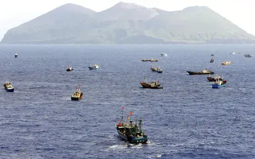 Foreign vessels, some of them have Chinese flags, fish near Torishima, Japan, on Oct. 31, 2014. A Chinese scientific ship bristling with surveillance equipment docked in a Sri Lankan port. Hundreds of fishing boats anchored for months at a time among disputed islands in the South China Sea. And ocean-going ferries, built to be capable of carrying heavy vehicles and large loads of people. (Kyodo News via AP)