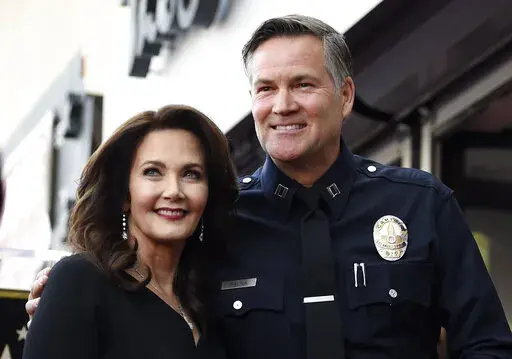 Actor Lynda Carter, left, poses with former Los Angeles Police Department Captain Cory Palka during a ceremony to award her a star on the Hollywood Walk of Fame, Tuesday, April 3, 2018, in Los Angeles. Palka's ties to Hollywood are under scrutiny after prosecutors say he leaked a sexual assault victim's confidential police report to CBS and its former leader Les Moonves. (AP Photo/Chris Pizzello, File)