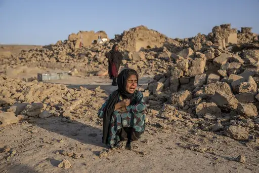 An Afghan girl cries in front of her house that was destroyed by the earthquake in Zenda Jan district in Herat province, western Afghanistan, Wednesday, Oct. 11, 2023. Another strong earthquake shook western Afghanistan on Wednesday morning after an earlier one killed more than 2,000 people and flattened whole villages in Herat province in what was one of the most destructive quakes in the country's recent history. (AP Photo/Ebrahim Noroozi)