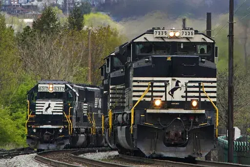 A Norfolk Southern freight train passes a train on a siding as it approaches a crossing in Homestead, Pa., Wednesday, April 27, 2022. Freight railroads and their unions are facing increasing pressure from business groups and the White House to settle their contract dispute. They face a looming strike deadline on Friday, Sept. 16, and business groups say a stoppage halting deliveries of raw materials and finished products that so many companies rely on would be an economic disaster. (AP Photo/Gen