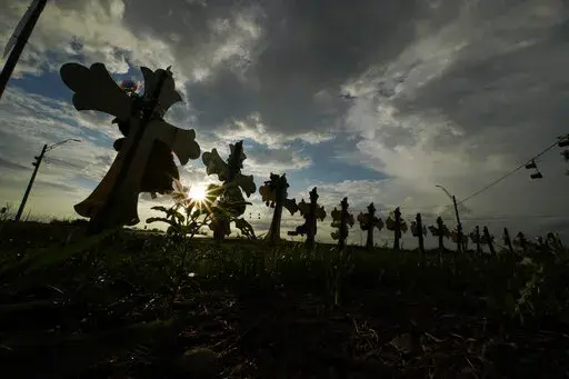 Vehicles pass crosses placed to honor the victims of the shootings at Robb Elementary School, Thursday, Aug. 25, 2022, in Uvalde, Texas. The Texas Department of Public Safety has fired an officer who was at the scene of the school massacre and becomes the first member of the state police force to lose their job in the fallout over the hesitant response to the May attack. (AP Photo/Eric Gay, File)