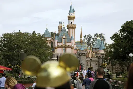 Visitors walk toward Sleeping Beauty's Castle in the background at Disneyland Resort on Jan. 22, 2015, in Anaheim, Calif. Disney CEO Bob Iger on Monday, April 3, 2023, called efforts by Florida Gov. Ron DeSantis and the Republican-controlled Florida Legislature to retaliate against the company for its policy positions as not only “anti-business but anti-Florida.” (AP Photo/Jae C. Hong, File)