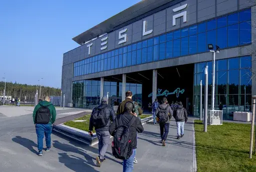 People walk to the Tesla Gigafactory for electric cars in Gruenheide near Berlin, Germany,March 13, 2024. After reporting dismal first-quarter sales, Tesla is planning to lay off about a tenth of its workforce as it tries to cut costs, multiple media outlets reported Monday. (AP Photo/Ebrahim Noroozi, File)