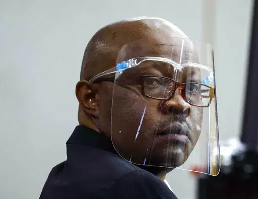 Accused serial killer Billy Chemirmir looks back ahead of his retrial on Monday, April 25, 2022, at Frank Crowley Courts Building in Dallas. The retrial of Chemirmir, charged with killing 18 older women in the Dallas area over a two-year span, began Monday, after the first jury to hear a case against him deadlocked last fall. (Shafkat Anowar/The Dallas Morning News via AP, Pool)