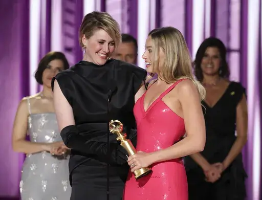 This image released by CBS shows co-director Greta Gerwig, left, and actor Margot Robbie accepting the award for best cinematic and box office achievement for the film "Barbie" during the 81st Annual Golden Globe Awards in Beverly Hills, Calif., on Sunday, Jan. 7, 2024. (Sonja Flemming/CBS via AP)