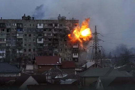 An explosion is seen in an apartment building after Russian's army tank fires in Mariupol, Ukraine, Friday, March 11, 2022. (AP Photo/Evgeniy Maloletka, File)
