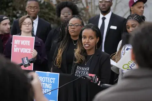 Harya Tarekegn with the Mississippi Center for Justice, center, joins members of other voting rights groups at a news conference in Jackson, Miss., on Thursday, Dec. 7, 2023. (AP Photo/Rogelio V. Solis)