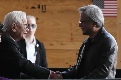 Taiwan Semiconductor Manufacturing Company founder Morris Chang, left, shakes hands with Nvidia Co-founder, President, and CEO Jensen Huang, right, at the TSMC facility under construction in Phoenix, Tuesday, Dec. 6, 2022. Nvidia shares skyrocketed early Thursday after the chipmaker forecast a huge jump in revenue for the next quarter, notably pointing to chip demand for AI-related products and services.(AP Photo/Ross D. Franklin, File)