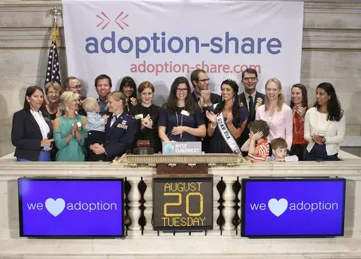 In this photo provided by the New York Stock Exchange, Adoption-Share founder and CEO Thea Ramirez, center, Miss Utah USA 2013 Marissa Powell, center right, and fellow adoption supporters ring the opening bell at the New York Stock Exchange in New York on Aug. 20, 2013. An Associated Press investigation found that Adoption-Share’s tool known as Family-Match – among the few adoption algorithms on the market in 2023 – has produced limited results in the states where it has been used, accordi
