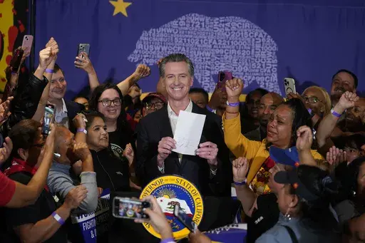 California Gov. Gavin Newsom signs the fast food bill surrounded by fast food workers at the SEIU Local 721 in Los Angeles, on Thursday, Sept. 28, 2023. Republican leaders in California are calling for an investigation into why a new state law requiring a $20 minimum wage for fast food workers includes an exemption for restaurants like Panera Bread. (AP Photo/Damian Dovarganes, File)