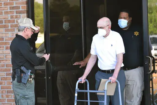 Paul West, center, is escorted by deputies from the Leflore County Civic Center in Greenwood, Miss., on Wednesday, April 13, 2022, after a jury found him guilty of sexually abusing a student at St. Francis of Assisi School in the 1990s. West, a former Franciscan friar, worked as a teacher and then principal at the Catholic school in Greenwood. Circuit Judge Ashley Hines sentenced West to 30 years on the first count and 15 years on the second. (Tim Kalich/The Commonwealth via AP)