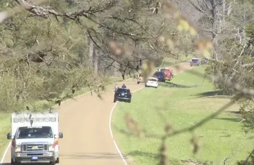 This image taken from video provided by WAPT shows first responders working the scene after a medical transport helicopter crashed Monday, March 10, 2025, in Madison County, Miss. (WAPT via AP)