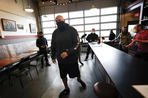 Democratic candidate for the Pennsylvania U.S.senate seat in the 2022 primary election, Lt. Gov. John Fetterman, arrives for a campaign stop at the Mechanistic Brewery, in Clarion, Pa., Saturday, Feb. 12, 2022. The Democratic Party's brand is so toxic in some parts of rural America that liberals are removing bumper stickers and refusing to acknowledge their party affiliation publicly.  (AP Photo/Keith Srakocic)