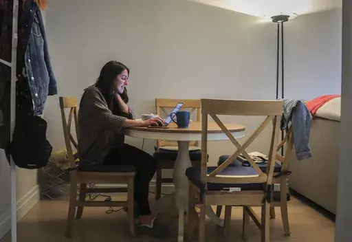 Lindsay Garfield, finance director at SquareFoot which helps companies find office space, works from home in New York on March 11, 2020. According to survey data from the U.S. Census Bureau, people working from home became younger, more diverse, better educated and more likely to move during the worst part of the COVID-19 pandemic, according to survey data from the U.S. Census Bureau. (AP Photo/Bebeto Matthews, File)