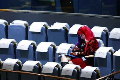 An attendee sits in the gallery during the 77th session of the United Nations General Assembly, at U.N. headquarters, Tuesday, Sept. 20, 2022. (AP Photo/Jason DeCrow)