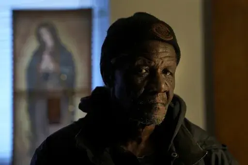 Rudolph Williams stands for a portrait in his apartment Monday, Jan. 8, 2024, in Harvey, Ill. Williams was home in the Chicago south suburb when he realized that the doors and windows to his courtyard-style apartment had been boarded up with plywood, locking him inside.(AP Photo/Charles Rex Arbogast)
